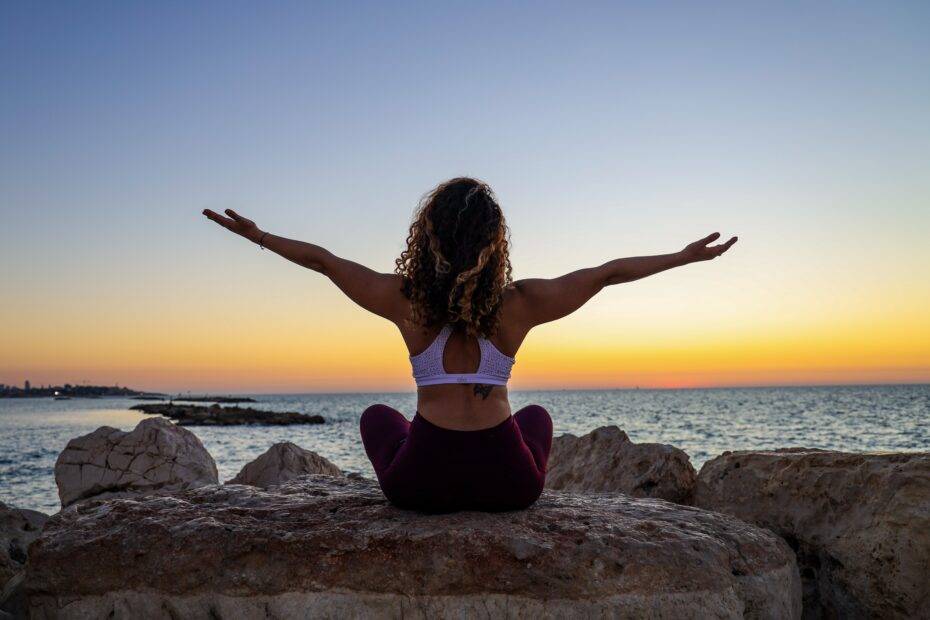 woman sitting on the stone in front of the ocean